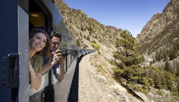 Guest standing in the viewing platform on Rocky Mountaineer.