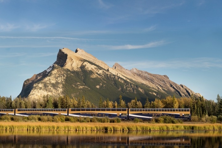 Train passing by mountain scenery.