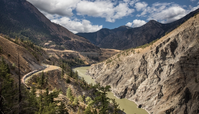 rocky mountaineer train goes by river along the rainforest to gold rush route to Quesnel