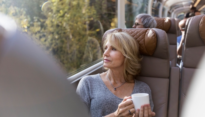 woman looks out the window while seated in goldleaf onboard the rocky mountaineer train
